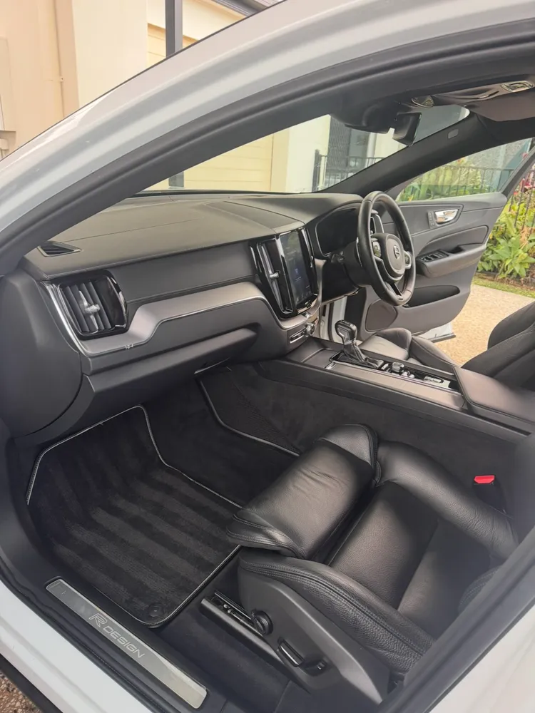 White Volvo XC60 R-Design interior detailed with leather seats and mats cleaned